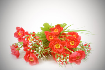 Artificial red flowers with vignette background.