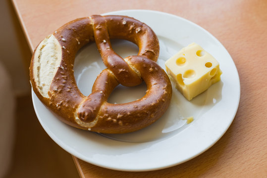 Austrian - german pretzel pretzl pastry with cheese on plate