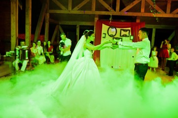 Obraz na płótnie Canvas Wedding dance in restaurant with varioius lights and smoke