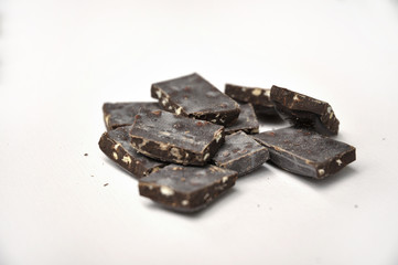 dark chocolate pieces on white background
