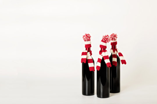 Merry Christmas and happy New year. Three bottles of wine in kni