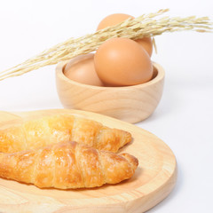 Double croissants and fresh eggs with wooden ware