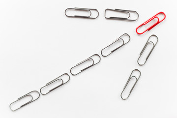 Metal paperclips in the shape of arrow up, red on the top, isolated on white background. Business concept, high angle