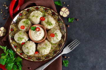 Khinkali with meat and spices with spicy cream sauce and garlic