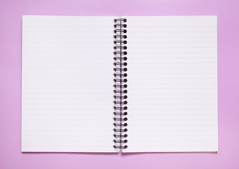 An open, blank notebook on a pastel pink background