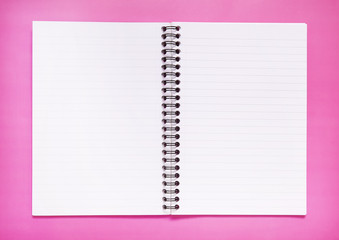 An open, blank notebook on a bright pink background