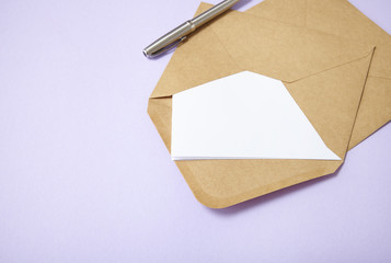 An open brown envelope with letter and writing pen on a pastel purple background forming a page border