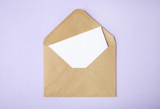 An open brown envelope with letter on a pastel purple background