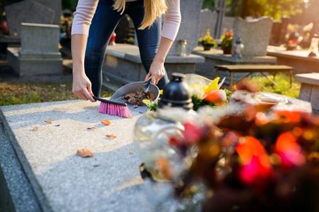 Woman cleans a grave.