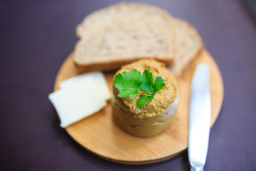Serve beef pate with a piece of butter and bread on a wooden board, decorated with parsley