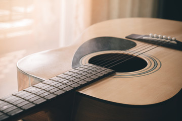 closeup picture of an acoustic guitar in a film tone, vintage st