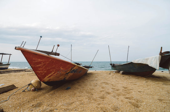 red traditional fisherman fiber boat on the sandy beach with whi