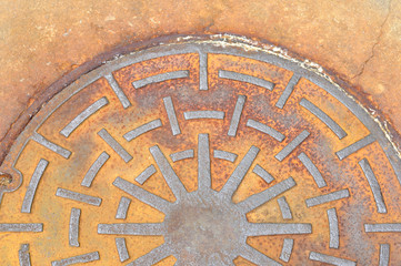 Rusty manhole cover on street, drain cover top view.