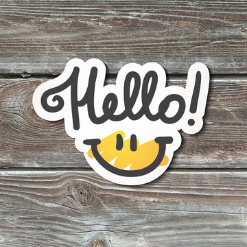hello lettering with smile, handwritten text, paper sticker on realistic wood texture