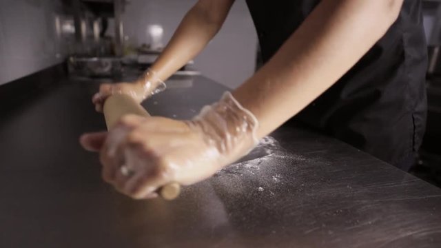 Chef preparing a pizza. Chef tossing pizza dough in commercial kitchen.
