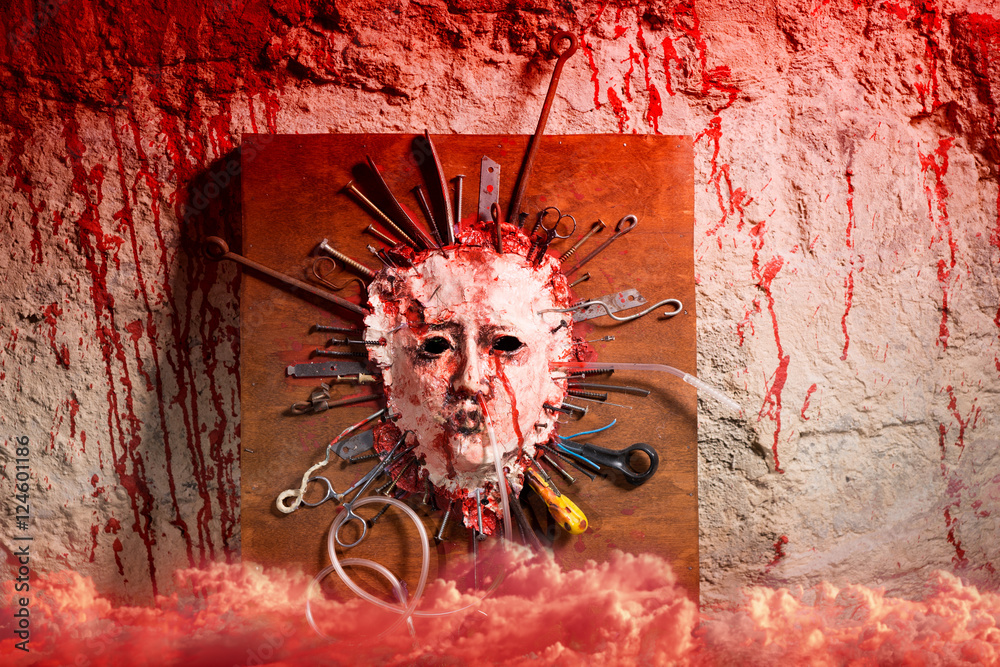 Wall mural skinned bloody face of a person with assorted sharp weapons with