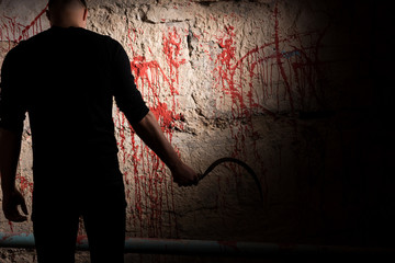 Shadowy figure near blood stained wall