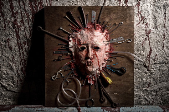 Frightful skinned bloody face of a person stretched open on a wo