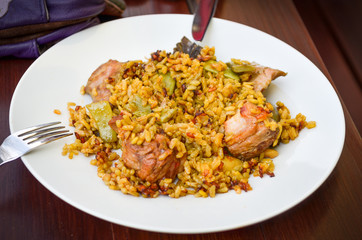 Eating traditional Spanish Paella on a white plate