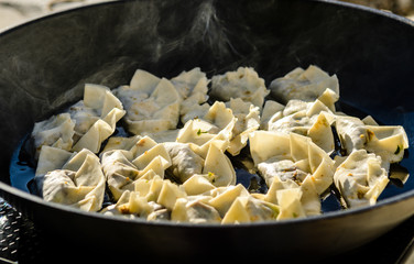 Making homemade Gyoza - Japanese Dumplings in frying pan.