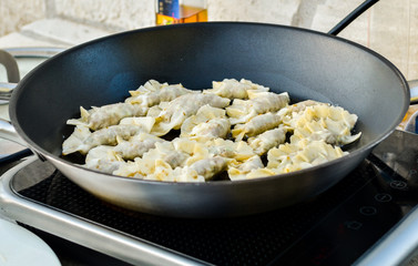 Making homemade Gyoza - Japanese Dumplings in frying pan.