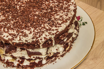 Сhocolate cake (half) is soaked in sour cream and decorated with chocolate shavings