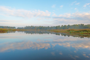 Fototapeta na wymiar Shore of a lake at sunrise in autumn