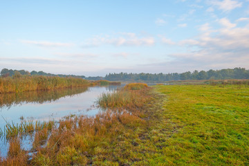 Shore of a lake at sunrise in autumn