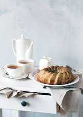 Banana tea cake served with two cups of tea in white composition