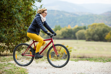 Urban biking - woman riding bike in city park 