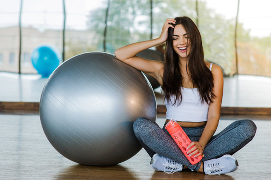 Young ethnic woman with fit ball sitting on floor while training in modern  gym · Free Stock Photo