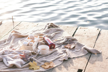 Warm knitted sweater,cup of hot tea and red thermos