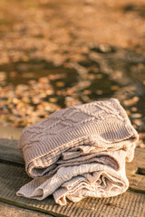 Pile of knitted winter clothes on wooden background, sweaters, k