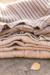 Fototapeta na wymiar Pile of knitted winter clothes on wooden background, sweaters, k