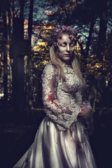 Fototapeta na wymiar Dressed in wedding clothes romantic zombie woman.