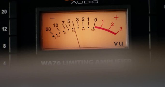 Audio meter on compressor unit powers up. Display lights up and needle goes up to red and back down again. Slow motion.