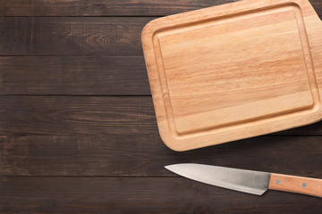 Knife and cutting board on the wooden background. 