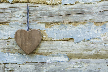 Wooden heart on a background of the old wall