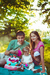 young family spends a picnic in the garden