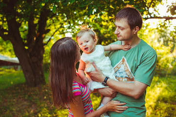 active family  with their baby walking   in garden