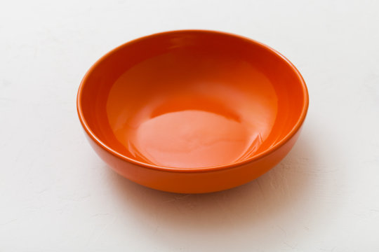 one orange bowl on white plaster