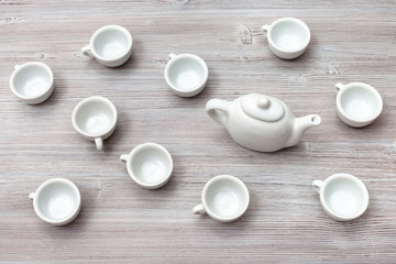 Fototapeta na wymiar top view of many white ceramic cups and teapot