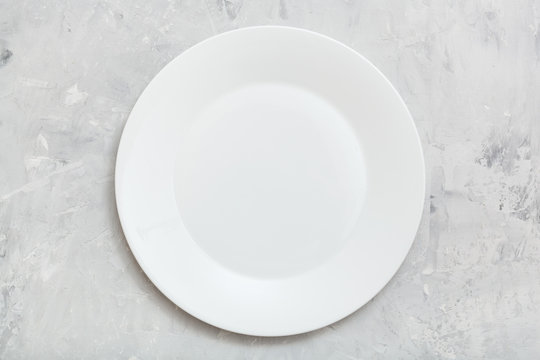 above view of white plate on gray concrete surface