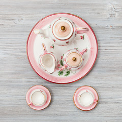 pink porcelain tea set on gray brown plank