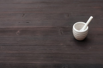 cup for sake with spoon on dark brown wooden board