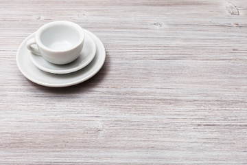 one white cup with saucers on gray brown table