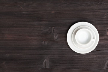 above view of cup with saucers on dark brown table