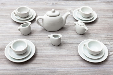 cups with saucers and tea set on gray brown board