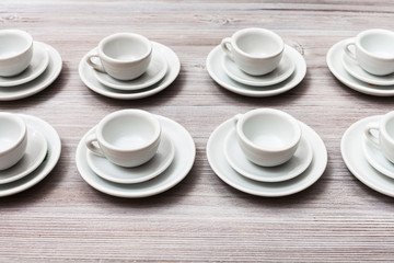 several white cups and saucers on gray brown table