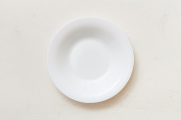 above view of white deep plate on plaster